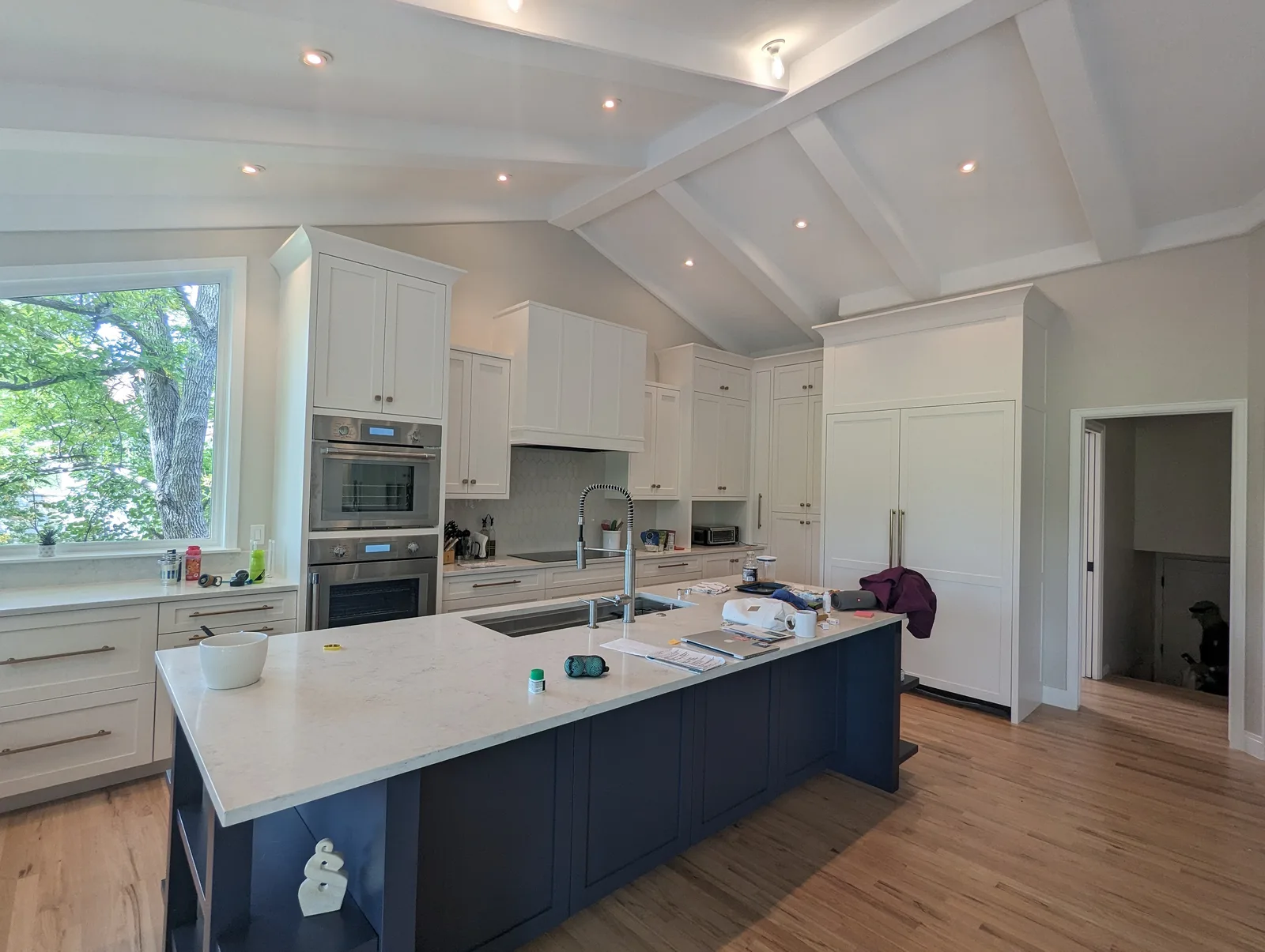 Large refinished kitchen with vaulted ceilings, white perimeter cabinets and a navy island in Northern Colorado