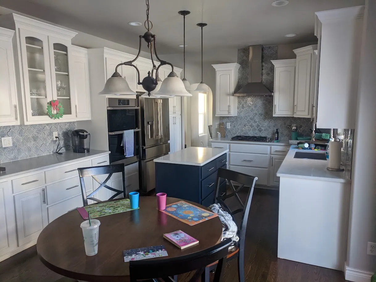Refinished two-tone kitchen with Pure White perimeter cabinets and a navy-painted island in Fort Collins