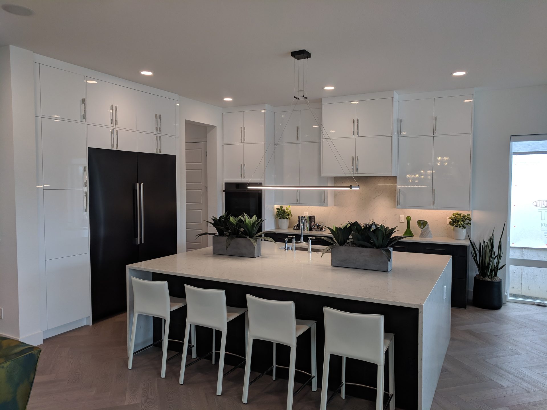 Bright white kitchen with a large finished island and bar seating