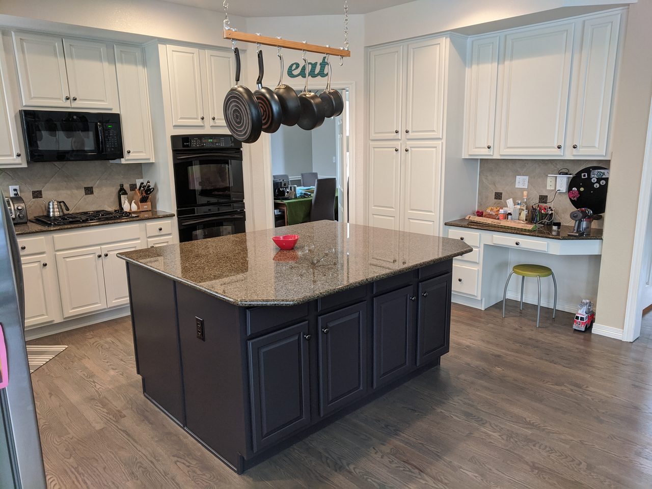 White kitchen with a dark finished island and pendant lights