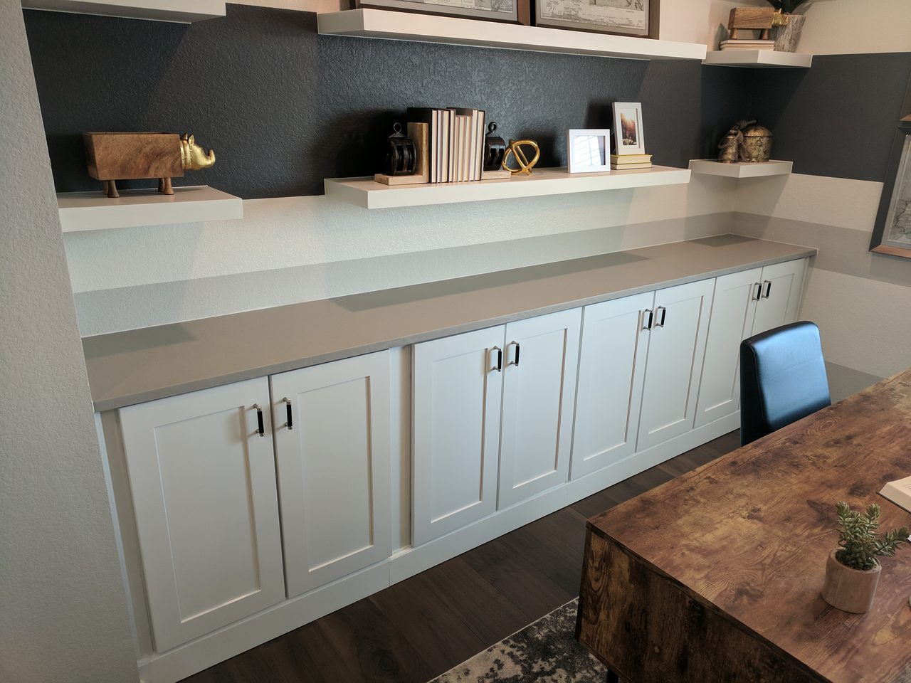 White kitchen with a dark finished floating shelf