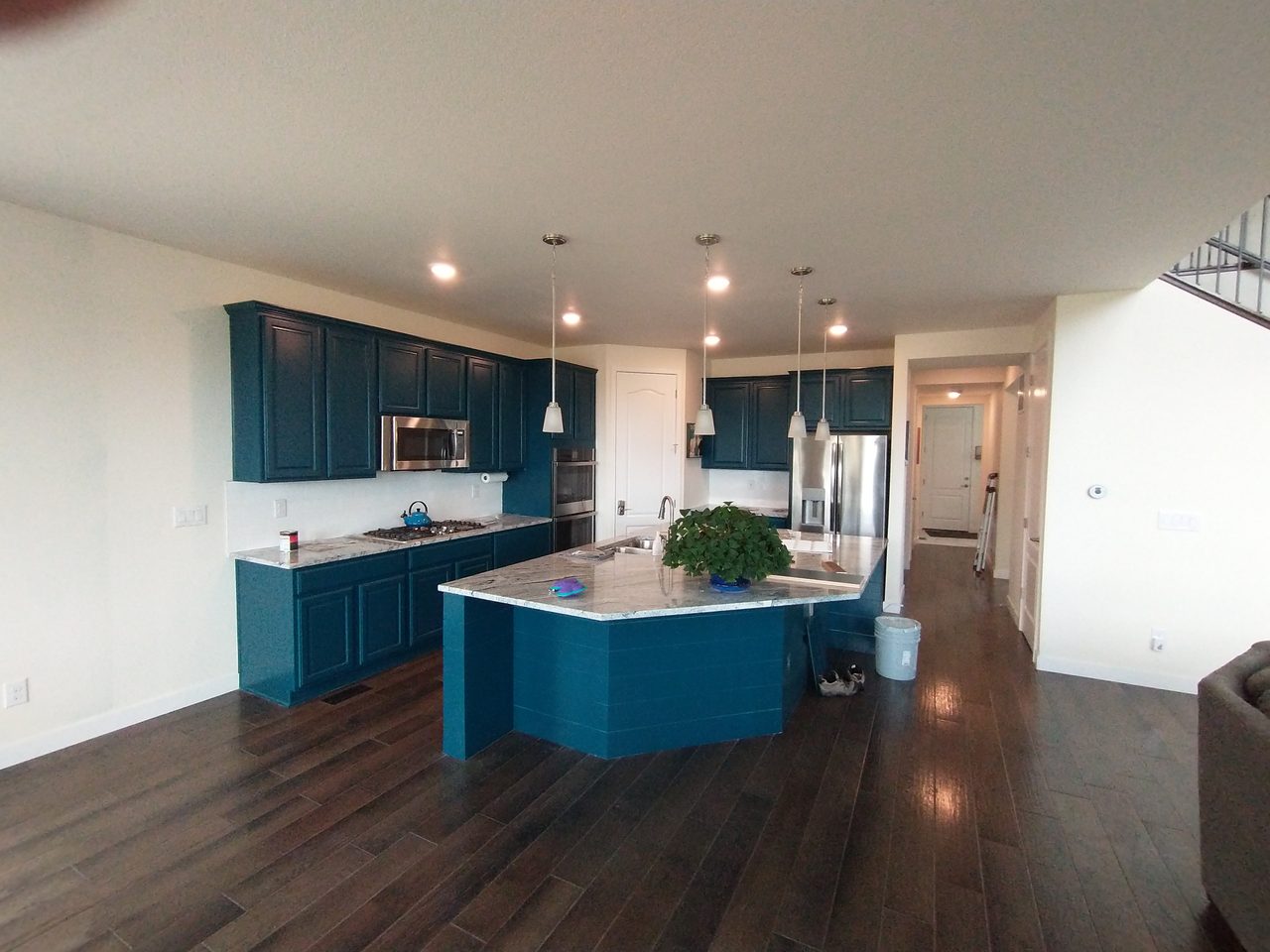Kitchen with white perimeter cabinets and a deep navy painted island