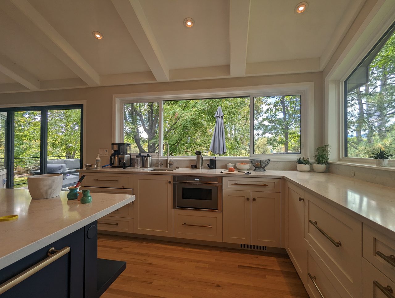 Open-concept kitchen with white cabinets and natural wood accents